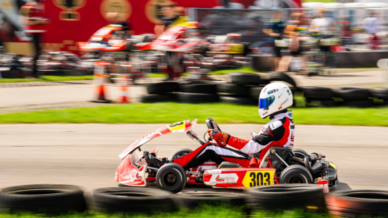Kartingo lenktynininkas važiuoja per lauko kartingų trasos klubą.